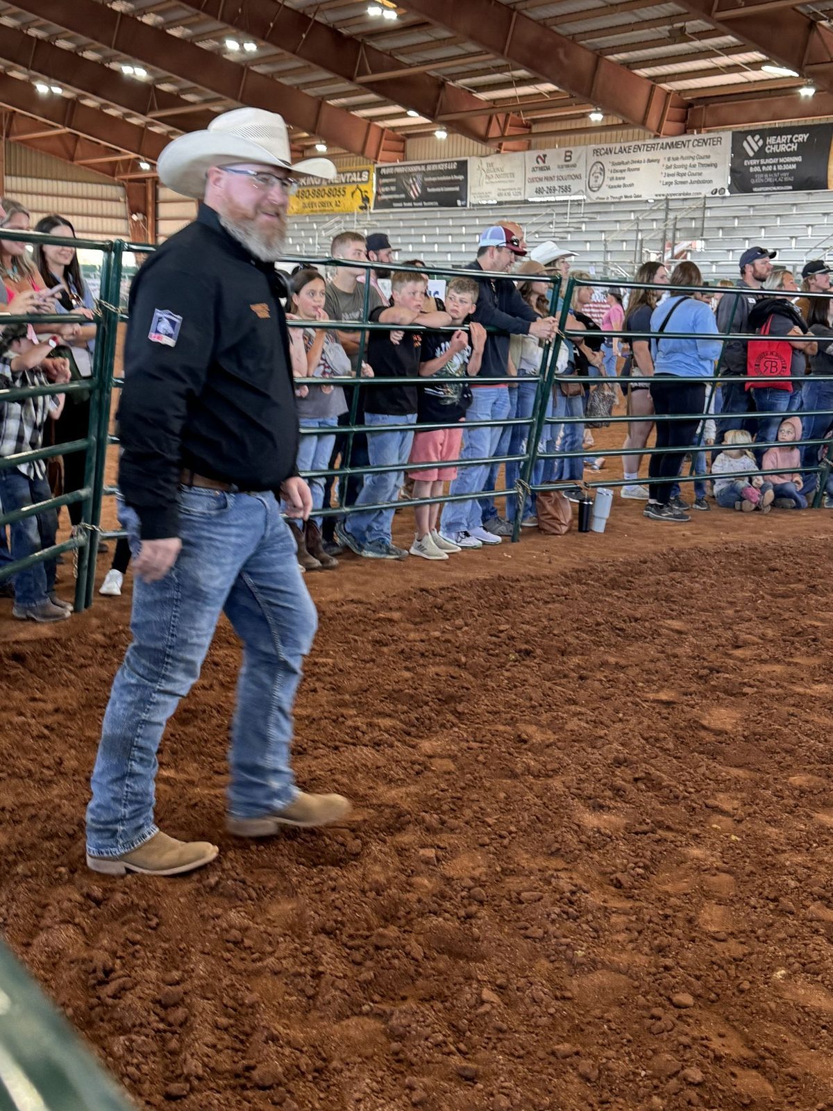 Joshua Morris working the arena floor at a packed indoor rodeo event